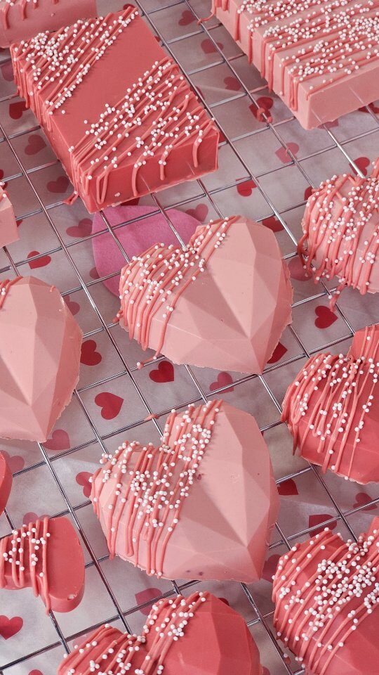 Pink heart-shaped chocolate-covered treats with sprinkles