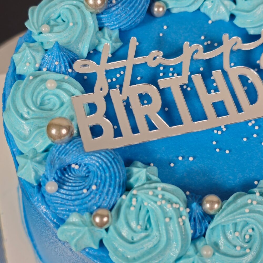 Blue buttercream Happy Birthday cake with rosettes and pearls