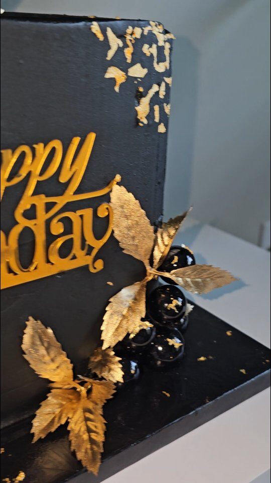 Black and gold cake with gold leaf accents